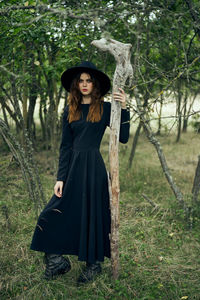 Portrait of young woman standing on field