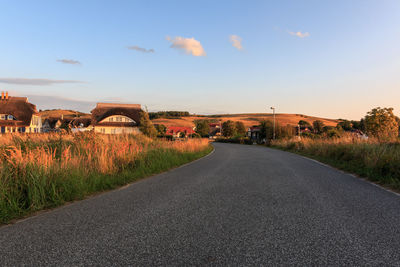 Road amidst field against sky