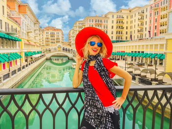 Full length of woman standing by railing in city