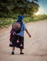 Rear view of woman walking on sand