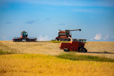 Tractor on agricultural field against sky