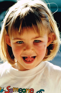 Portrait of playful girl with short hair sticking out tongue