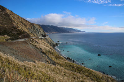 Scenic view of sea and mountains against sky