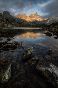 Scenic view of lake by mountains against sky