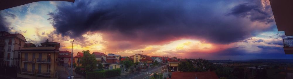Panoramic view of town against cloudy sky during sunset