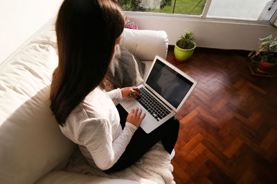 High angle view of woman using mobile phone at home
