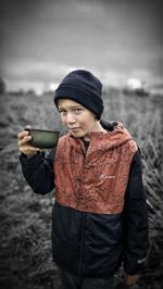 Portrait of young man standing against sky