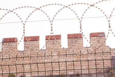 Barbed wire fence against sky