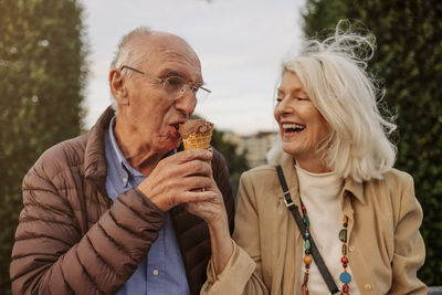 Happy senior couple sharing ice cream