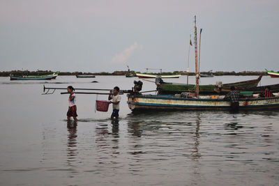 People on sea against sky