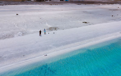 Aerial view of people standing at beach