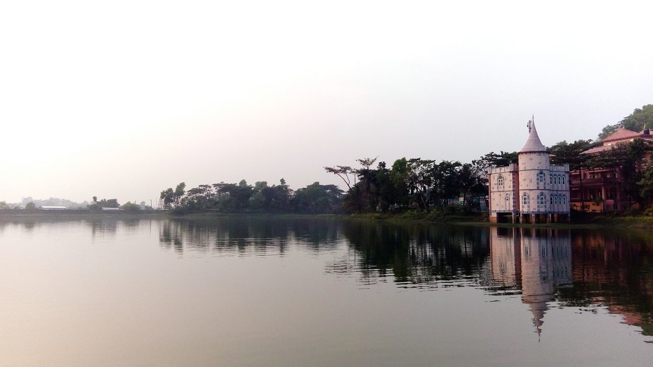 water, architecture, building exterior, built structure, waterfront, reflection, clear sky, lake, tree, copy space, river, tranquility, tranquil scene, standing water, nature, sky, outdoors, no people, beauty in nature, scenics