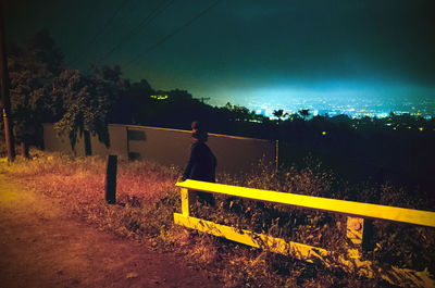 Man on road against sky at night