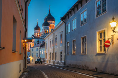 Illuminated mosque against sky in city