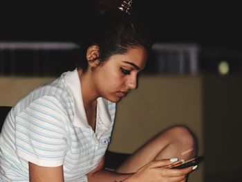 Young woman using mobile phone at home