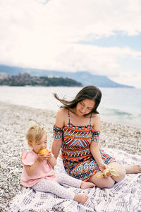 Full length of woman sitting on beach