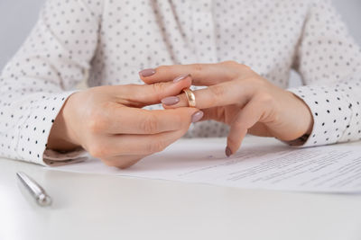 Midsection of woman holding hands on table