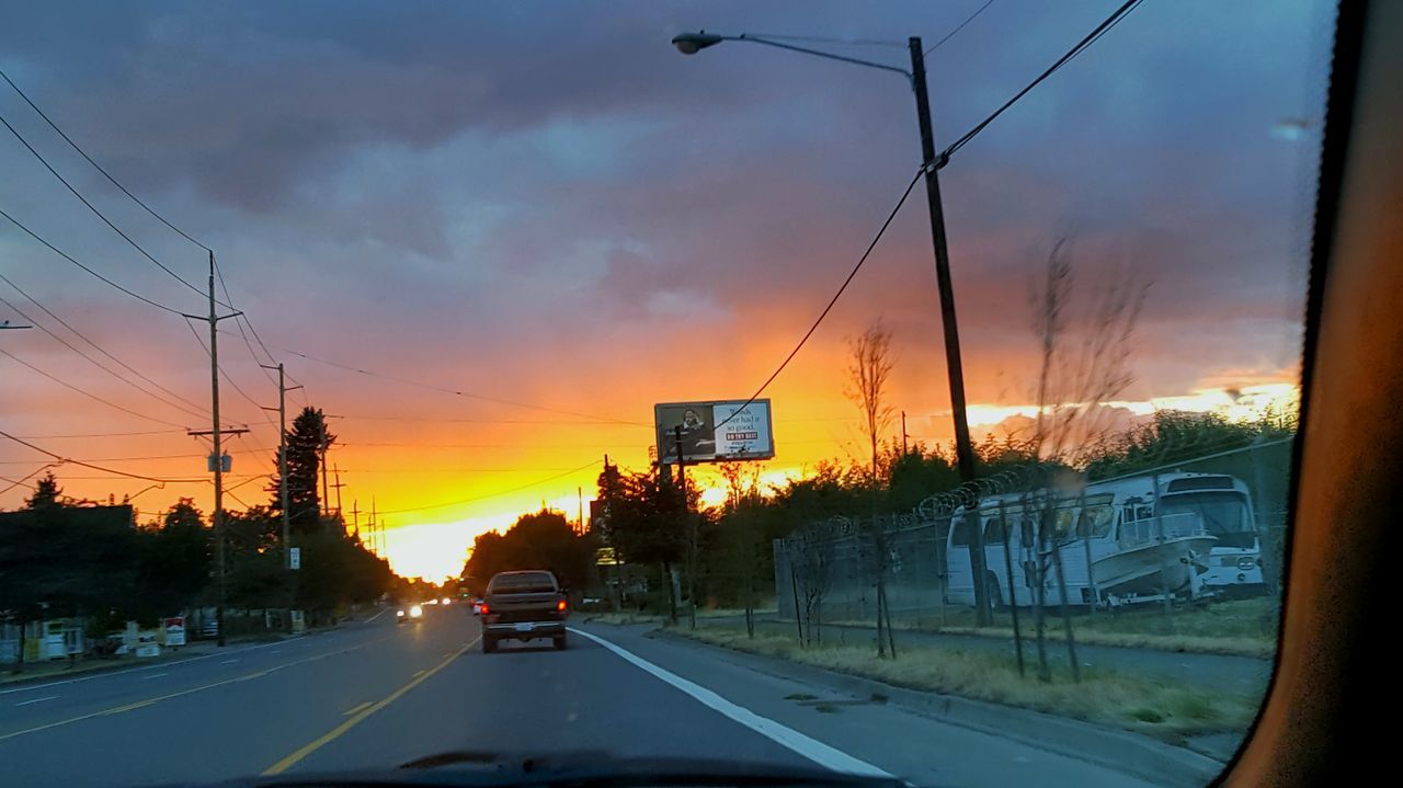 transportation, sunset, car, road, land vehicle, mode of transport, sky, orange color, cloud - sky, vehicle interior, road marking, street, transparent, the way forward, glass - material, windshield, diminishing perspective, on the move, electricity pylon, power line