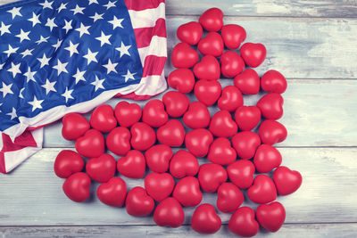 Directly above shot of heart shape toys by american flag on table