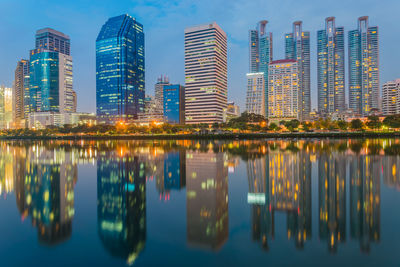 Reflection of city on lake against sky