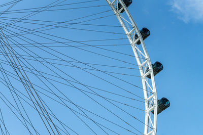 Low angle view of ferris wheel against blue sky