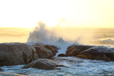 Scenic view of rocks in sea against sky