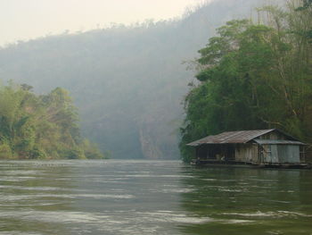 Scenic view of lake by trees during rainy season