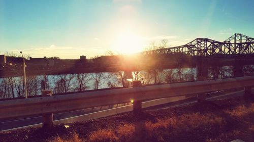 Bridge over river against sky during sunset