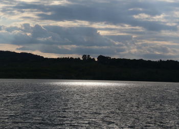 Scenic view of lake and silhouette landscape against sky