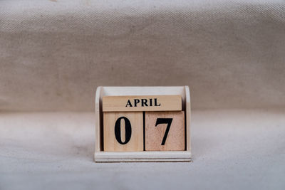 Close-up of information sign on table against wall