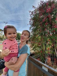 Happy girl smiling while standing against plants