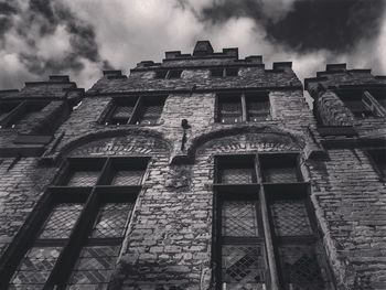 Low angle view of old building against cloudy sky