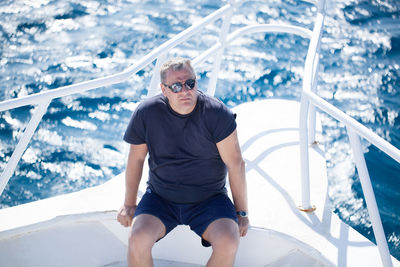 Mature man sitting in boat at sea
