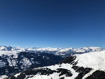 Scenic view of snowcapped mountains against clear blue sky