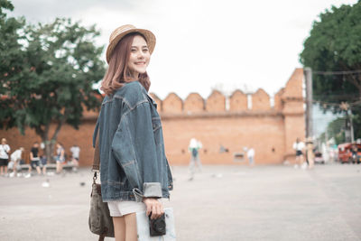 Beautiful young woman standing at park