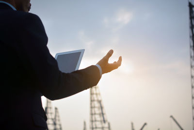 Low angle view of man using mobile phone against sky