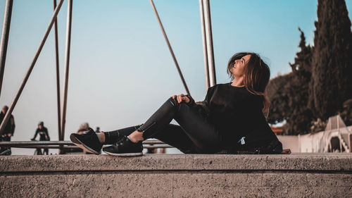 Woman sitting against sky