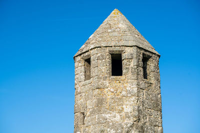 Low angle view of old building against clear blue sky