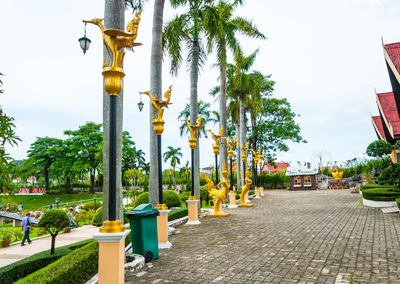 Street light by palm trees against sky