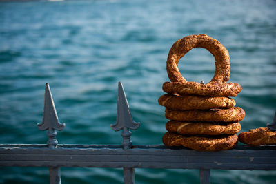 Close-up of rusty metal railing by pier against sea