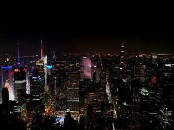 Illuminated cityscape against sky at night