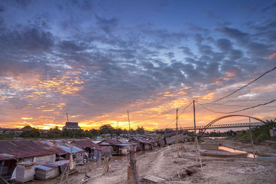 Scenic view of beach against dramatic sky during sunset