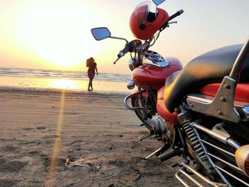 People riding motorcycle on beach against sky