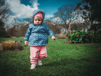 Portrait of girl standing on grassy field