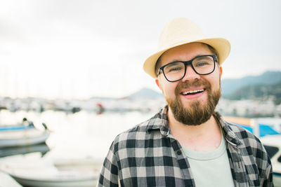 Portrait of young man wearing sunglasses against sky