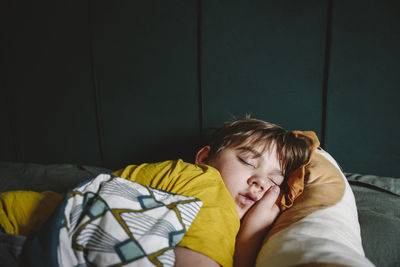 Boy sleeping in bed at home