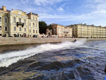 Buildings by sea against sky in city