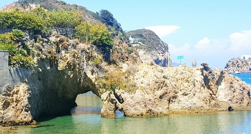 Rock formations by sea against sky