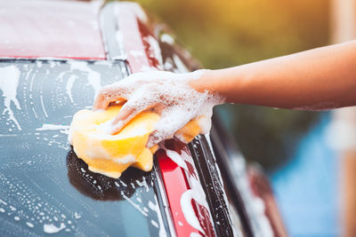 Cropped image of hand washing car