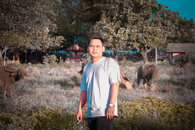 Portrait of smiling young man standing on land